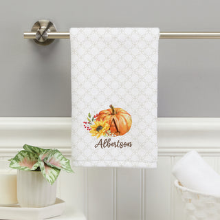 Hand towel featuring a fall floral pumpkin design, personalized with an initial and name in elegant script