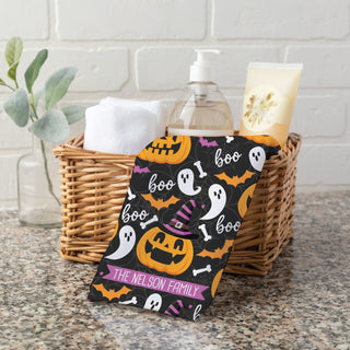 Hand towel featuring a spooky Halloween design with pumpkins, ghosts, and bones  personalized with a name.