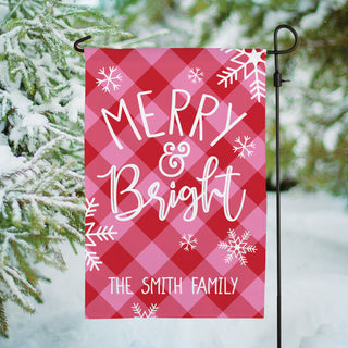 Garden flag featuring a "Merry & Bright" message with a pink and red check pattern with personalization at the bottom.