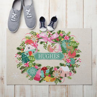 Thin doormat featuring a whimsical ornament wreath design, personalized with a name for a in the center