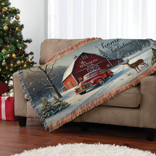 Fringe throw blanket featuring a "Home For The Holidays" text with a red barn, personalized with a name for a cozy, festive touch